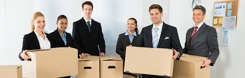 Employees In Office Holding Cardboard Boxes